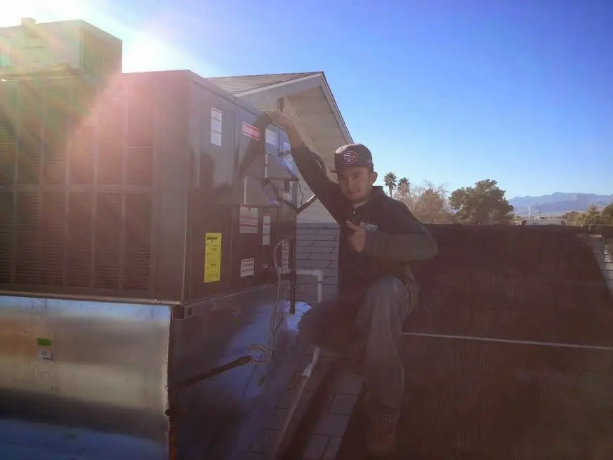 HVAC technician performing AC Tune-Up on a rooftop unit in Corinth